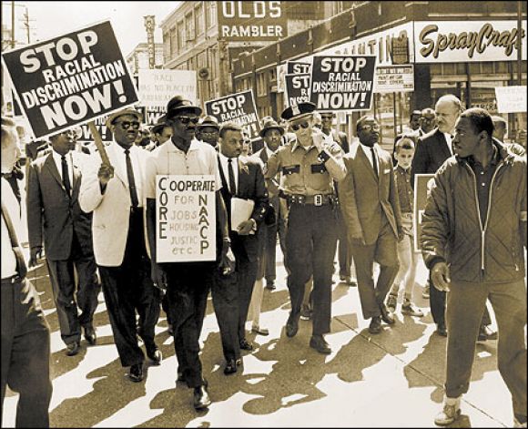 The Rev. Mance Jackson (center, next to police officer) leading demonstrators in downtown Seattle Seattle Post-Intelligencer